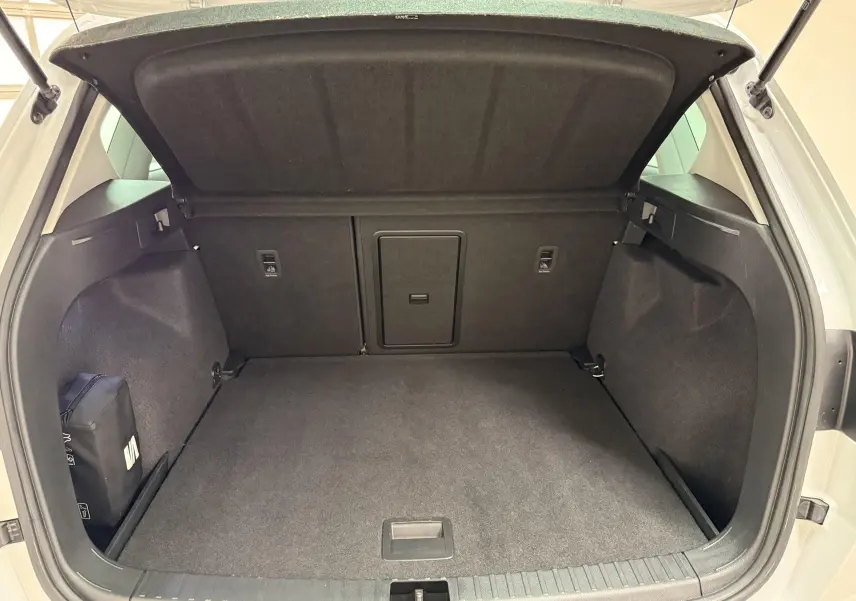 Coffre ouvert du SEAT Ateca blanc Nevada 2023, vue arrière montrant le plancher à double fond et l’espace de rangement.