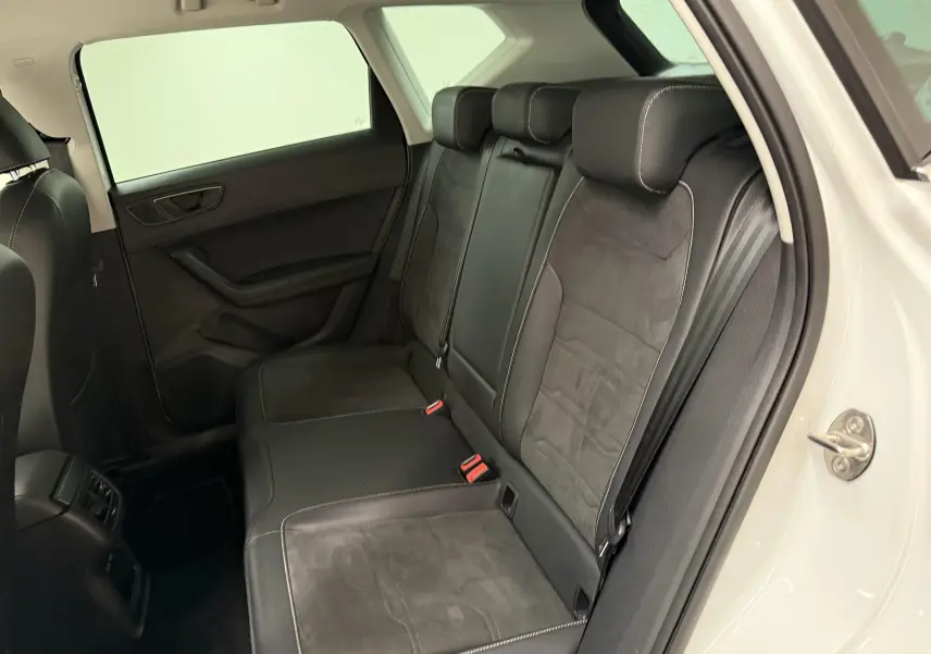 Vue intérieure côté droit des sièges arrière en cuir noir avec surpiqûres blanches du SEAT Ateca blanc Nevada 2023.