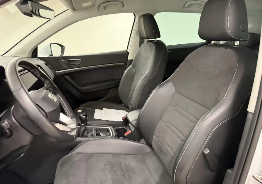 Vue intérieure côté conducteur du SEAT Ateca 2023 avec sièges en cuir noir et volant multifonction.