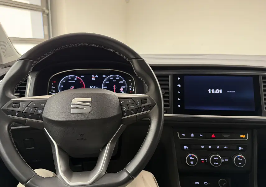 Vue intérieure centrée sur le volant et le tableau de bord numérique du SEAT Ateca 2023, ambiance sobre et moderne.