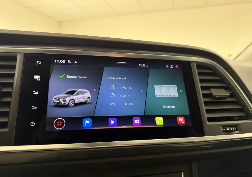 Écran tactile central affichant l'interface multimédia du SEAT Ateca blanc Nevada, vue intérieure frontale.