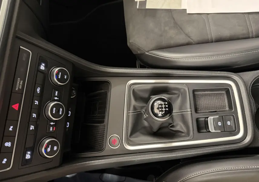 Vue plongeante sur la console centrale du SEAT Ateca blanc Nevada 2023, mettant en valeur le levier de vitesses manuel et les commandes climatisation.