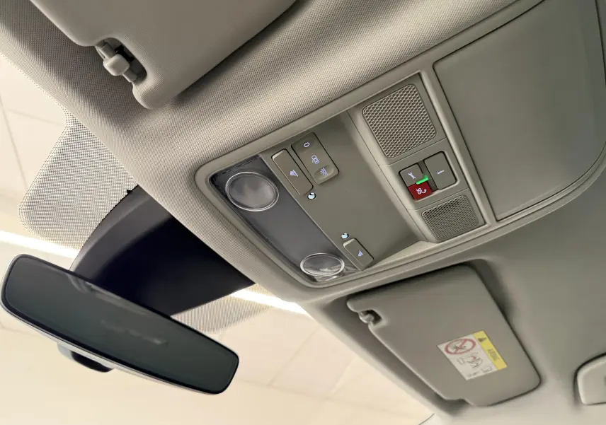 Vue intérieure du plafond avant du SEAT Ateca blanc Nevada 2023, avec commandes d'éclairage et rétroviseur central.