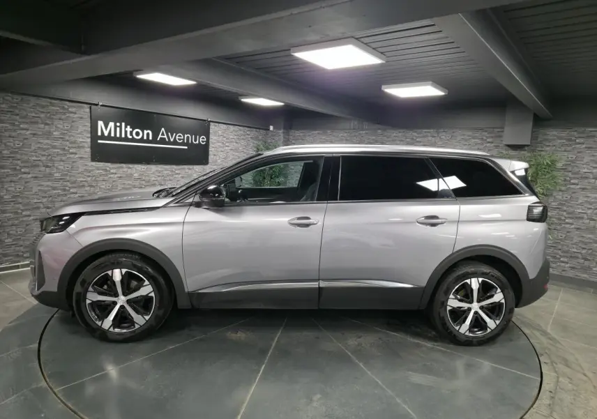 Peugeot 5008 gris métallisé vue de profil côté gauche, avec jantes alliage bi-ton et vitres surteintées.