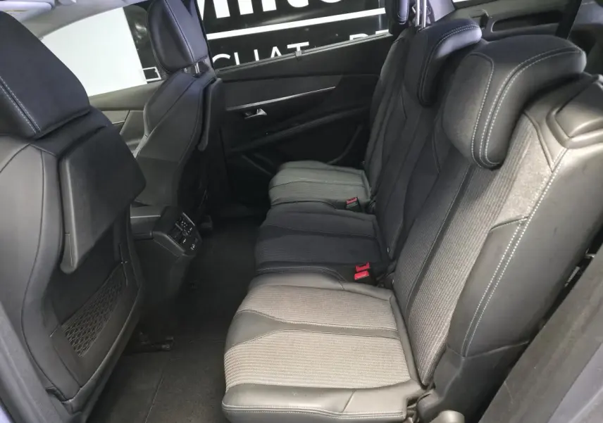 Vue latérale intérieure des sièges arrière gris et noirs du Peugeot 5008 2022 avec appuis-tête réglables et coutures contrastées.