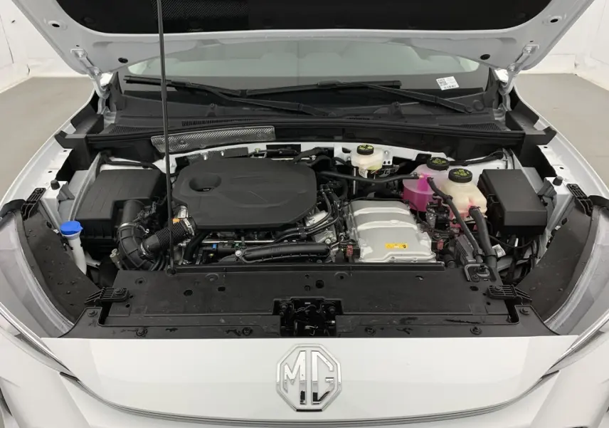 Vue de face sous le capot ouvert du MG ZS Dover White 2026, montrant le moteur hybride et les réservoirs fluides.