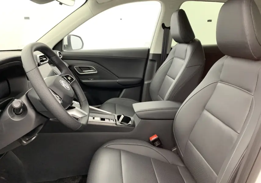Vue intérieure côté gauche du MG ZS 1.5 L Hybrid+ 2026, sièges en similicuir noir et volant cuir microfibre.