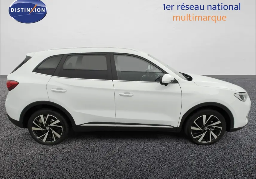 Vue de profil côté droit du SUV MG ZS 1.5 L Hybrid+ 197 ch Luxury en blanc Dover avec jantes alliage 18 pouces.