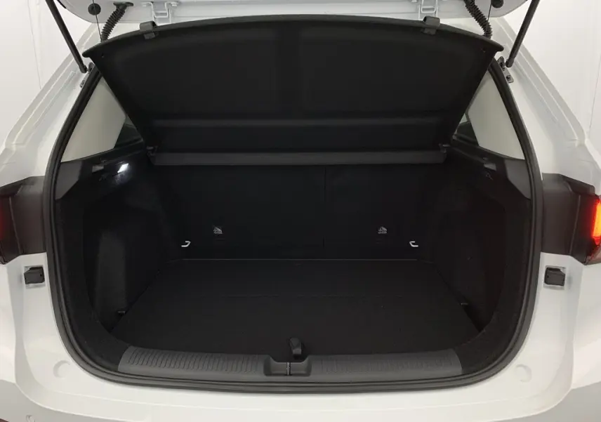 Coffre ouvert vu de l'arrière du MG ZS Dover White 2026, montrant l'espace de chargement noir et la trappe de séparation.