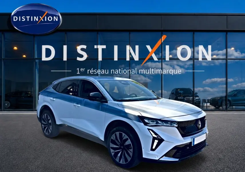 Renault Rafale blanc en 3/4 avant droit, avec feux LED et jantes alu distinctives, devant vitrine Distinxion.