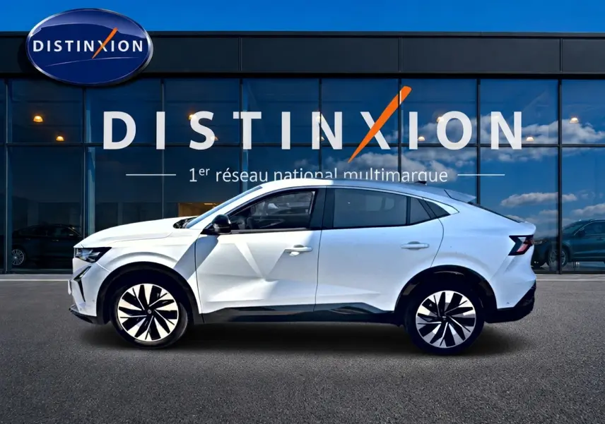 Renault Rafale blanc en profil droit, SUV coupé avec jantes noires et blanches, devant vitrine Distinxion.