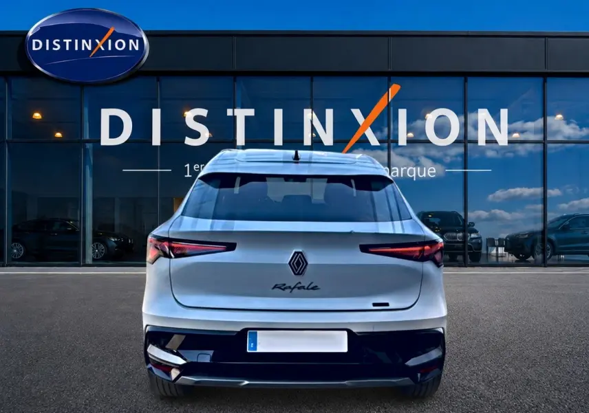 Vue arrière d'une Renault Rafale blanche 2025 garée devant une vitrine avec logo Distinxion.
