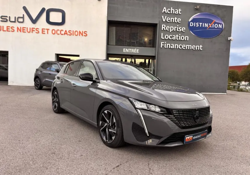 Peugeot 308 Hybrid gris vue 3/4 avant droit, jantes alliage 17 pouces et calandre noire distinctive.