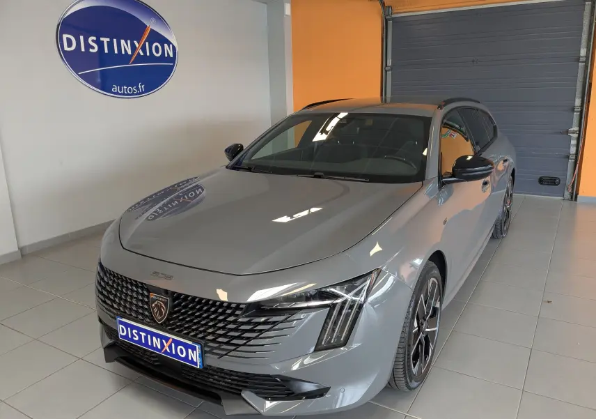 Peugeot 508 SW gris selenium vue 3/4 avant droit, avec calandre noire distinctive et jantes aluminium 18 pouces.
