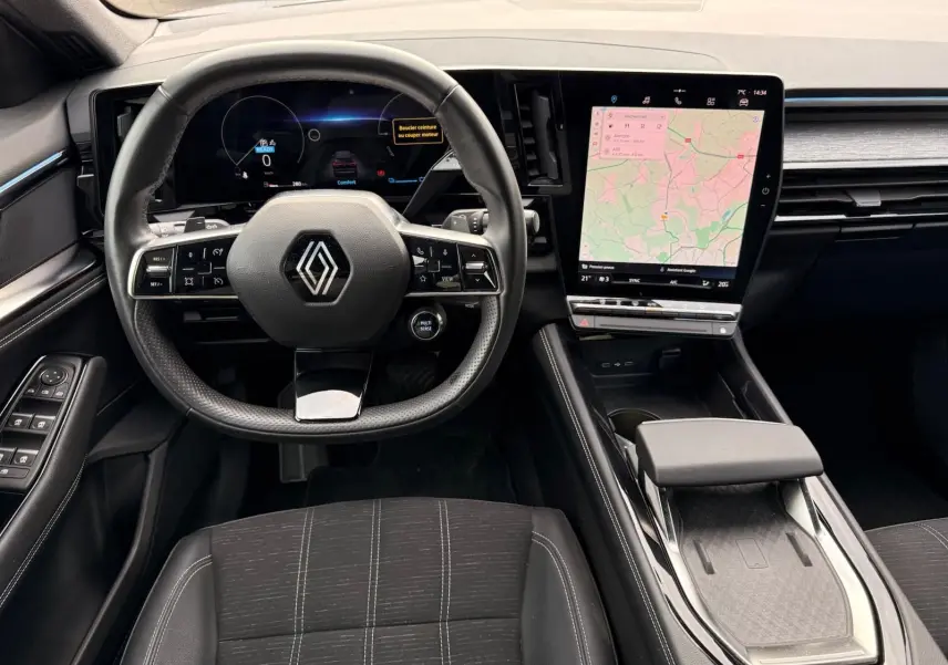 Vue intérieure du poste de conduite du Renault Austral E-Tech 200, avec volant multifonction et écran tactile central vertical.