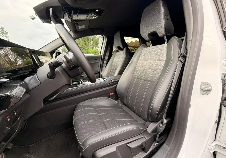 Intérieur côté conducteur du Renault Austral E-Tech 200 blanc nacré, sièges tissu et cuir gris avec surpiqûres blanches.