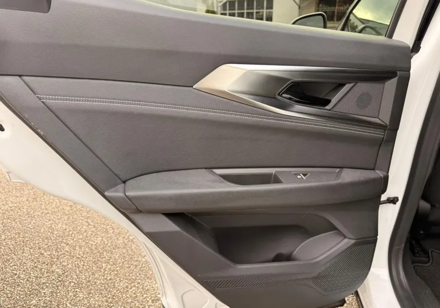 Vue intérieure de la porte arrière droite du Renault Austral E-Tech blanc nacré avec garniture noire et surpiqûres grises.