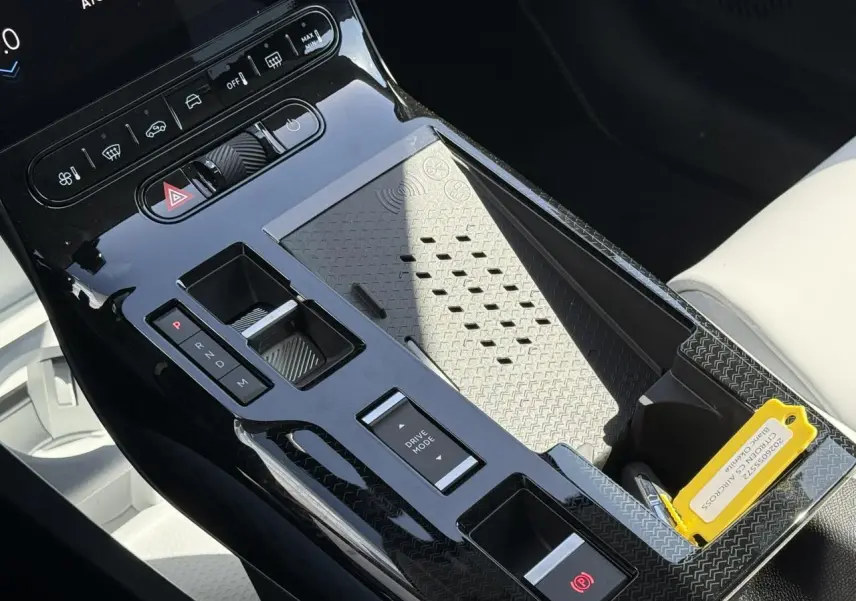 Vue rapprochée de la console centrale noire brillante du Citroën C5 Aircross blanc, avec commandes de boîte auto et mode de conduite.