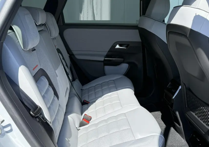 Vue latérale droite de la banquette arrière blanche et grise du Citroën C5 Aircross 2025 avec appuie-têtes et filets de rangement.