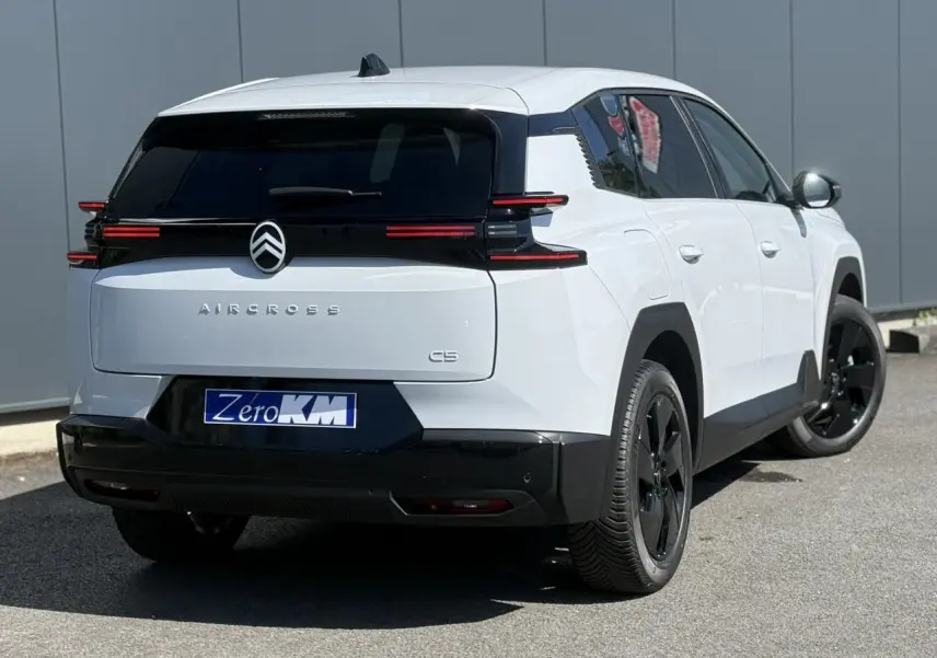 Vue 3/4 arrière droite du Citroën C5 Aircross blanc Okénite avec toit noir et jantes alliage noires.