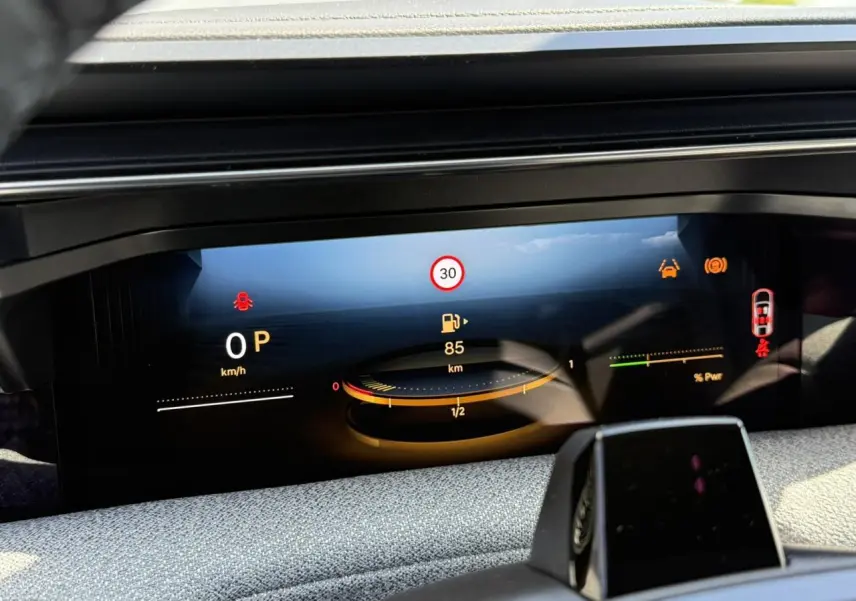 Affichage numérique du tableau de bord du Citroën C5 Aircross hybride, montrant la vitesse, autonomie et alertes.
