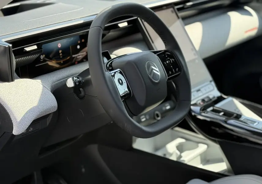 Vue intérieure côté conducteur du Citroën C5 Aircross blanc, volant multifonctions et grand écran tactile vertical.