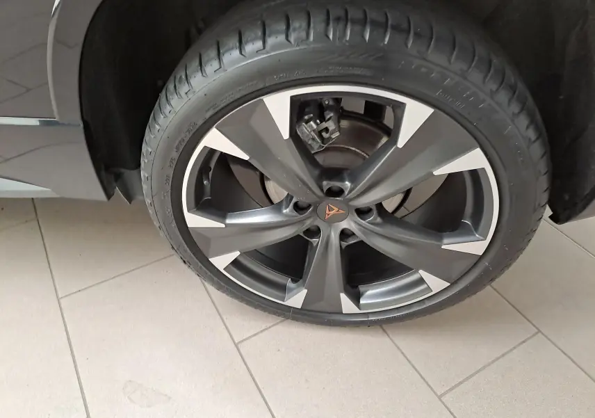 Gros plan sur la roue avant gauche du CUPRA Ateca 2024 noir magique, mettant en valeur la jante alliage bicolore et le logo CUPRA central.