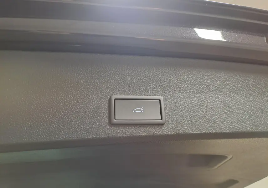 Bouton d'ouverture électrique du coffre sur la trappe intérieure d'un CUPRA Ateca Noir Magique 2024.