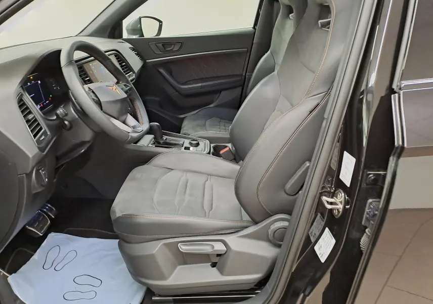 Intérieur côté conducteur du CUPRA Ateca 2024 noir magique, sièges sport en cuir et alcantara avec surpiqûres orange.