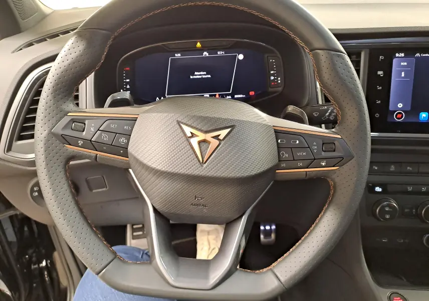 Vue rapprochée du volant perforé noir avec surpiqûres cuivrées et logo CUPRA au centre du SUV Ateca 2024.