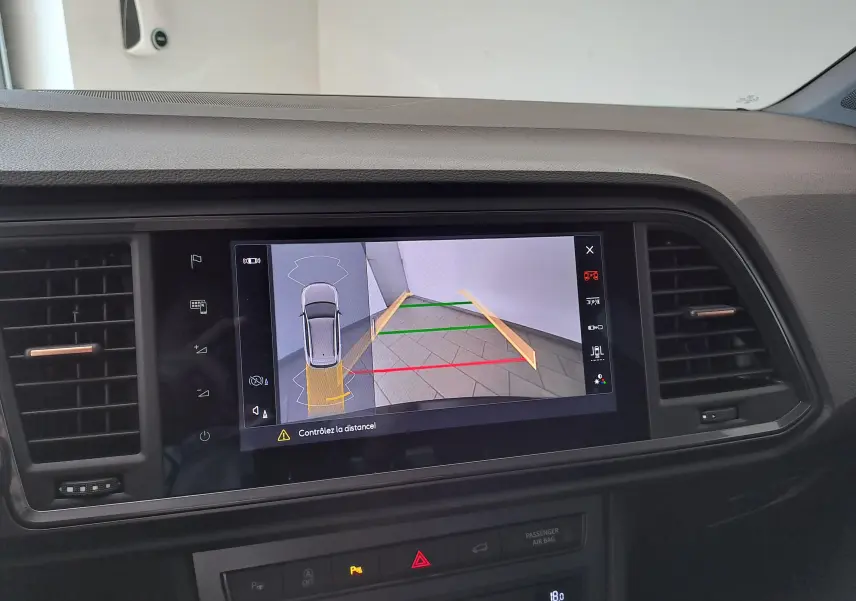Vue intérieure du tableau de bord du CUPRA Ateca 2024 avec écran multimédia affichant la caméra de recul en marche.