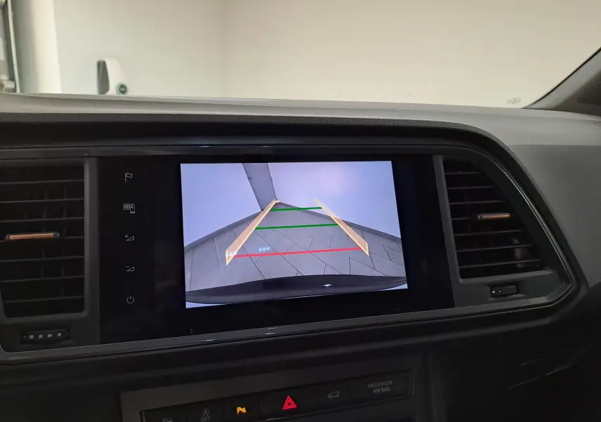 Vue intérieure du tableau de bord d'une CUPRA Ateca 2024 noir magique, avec l'écran affichant la caméra de recul et ses repères colorés.