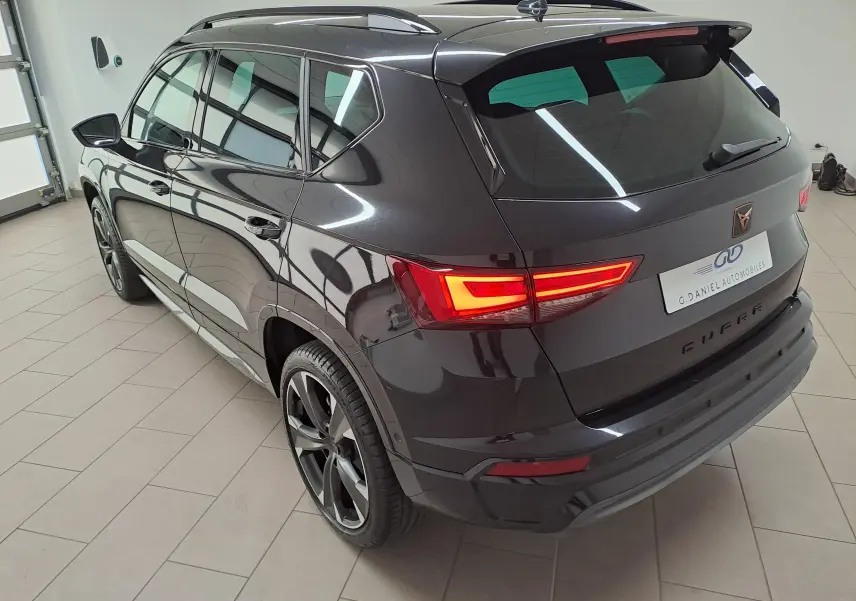 Vue 3/4 arrière droite du CUPRA Ateca 2024 noir magique avec feux arrière allumés et jantes noires distinctives.