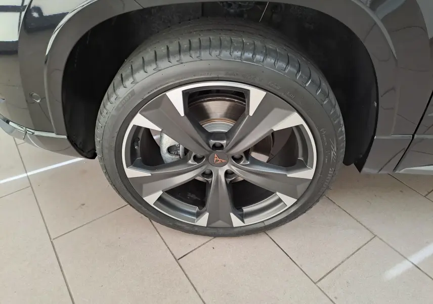 Gros plan sur la roue avant gauche du CUPRA Ateca 2024 noir magique, mettant en valeur la jante alliage distinctive.