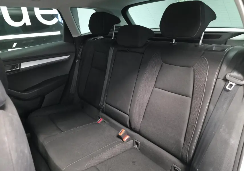 Vue intérieure du côté gauche de la banquette arrière noire du Skoda Karoq 2024 avec appuie-têtes et ceintures visibles.