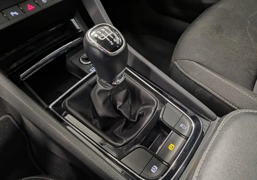 Gros plan sur le levier de vitesses manuel noir et la console centrale du Skoda Karoq 2024, intérieur tissu noir.