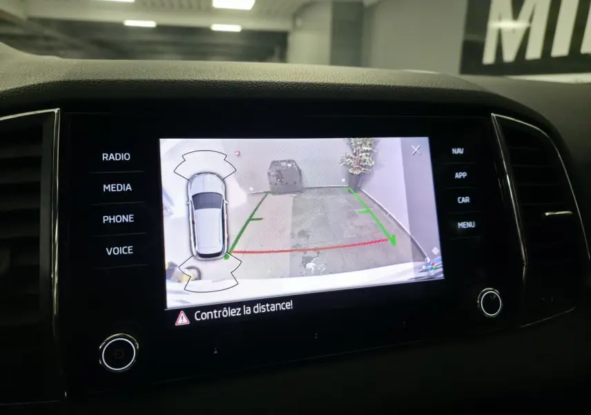 Écran tactile intérieur du Skoda Karoq 2024 montrant l’aide au stationnement avec caméra de recul active.