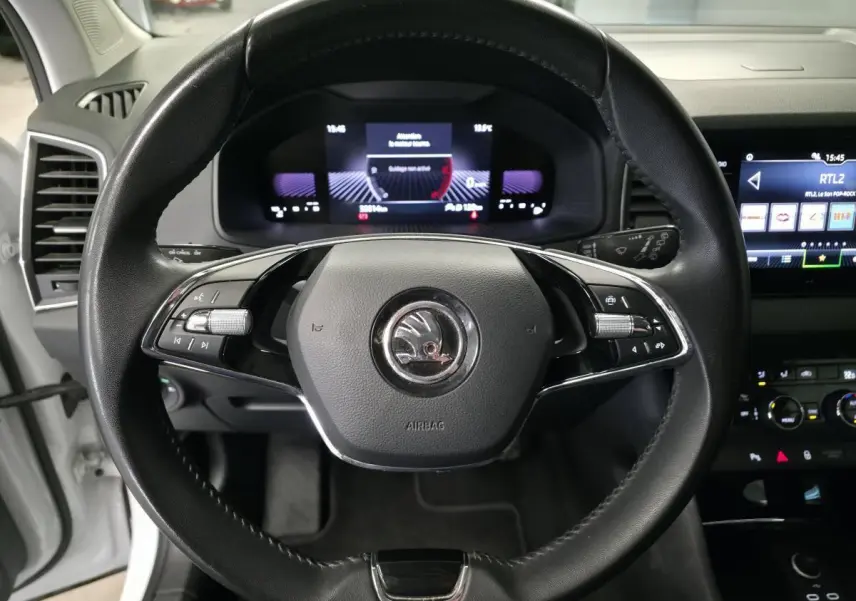 Vue frontale du volant noir de la Skoda Karoq 2024 avec tableau de bord digital et écran tactile visible à droite.