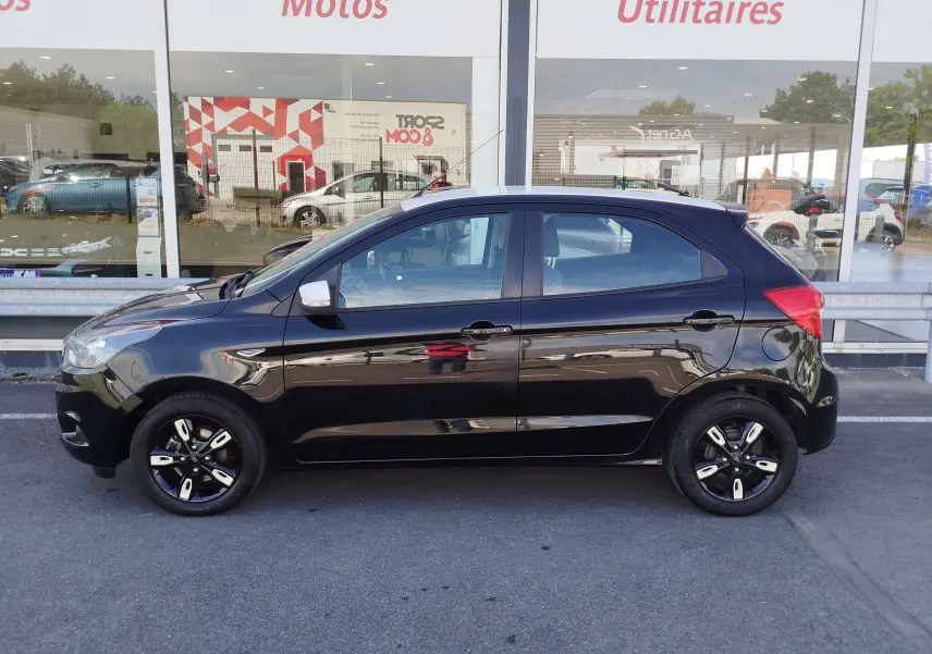 Ford KA+ 2020 noir Shadow avec toit blanc, vue profil côté gauche, jantes noires bi-ton et rétroviseurs blancs.