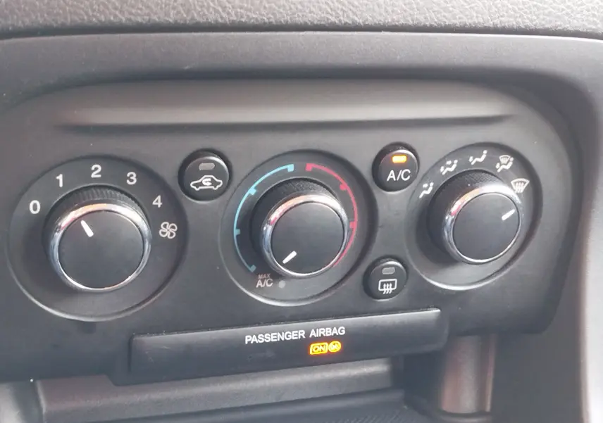 Tableau de bord en gros plan du Ford KA+ 2020, montrant les commandes de climatisation avec voyants allumés.