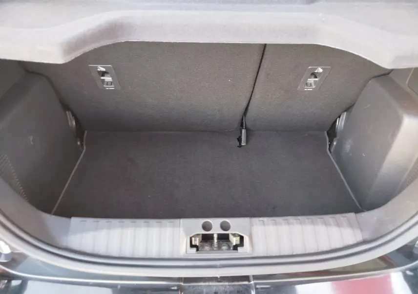 Coffre ouvert vu de face d'une Ford KA+ 1.2 Ti-VCT 85ch Édition Noire noir Shadow avec toit blanc, intérieur de coffre noir.
