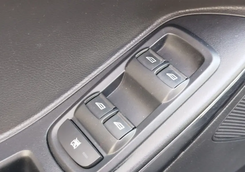 Gros plan sur les commandes de lève-vitres électriques côté conducteur du Ford KA+ 1.2 Ti-VCT 85ch Édition Noire, intérieur noir.