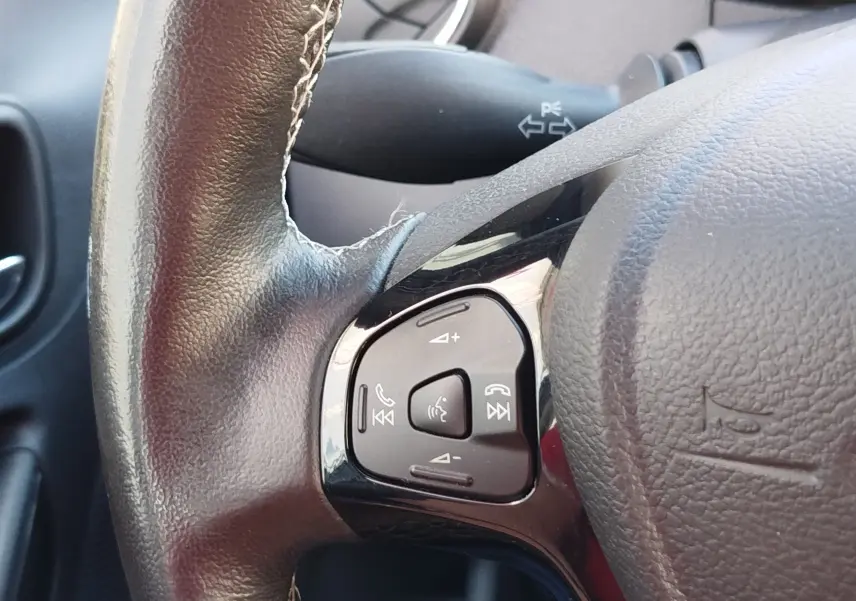 Gros plan sur les commandes vocales et téléphoniques sur le volant en cuir noir du Ford KA+ 2020.