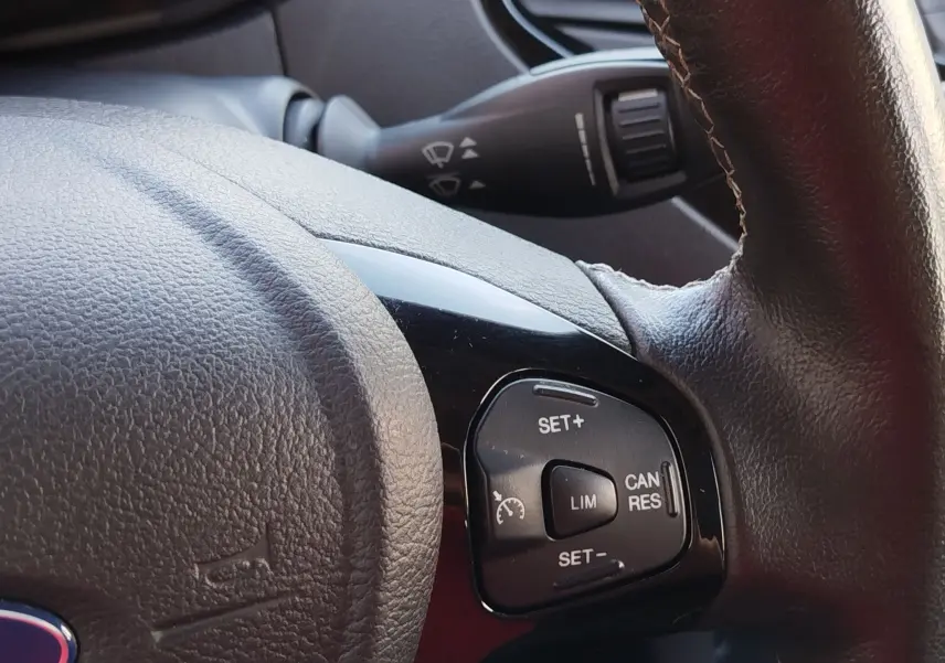 Gros plan sur les commandes de régulateur de vitesse à droite du volant en cuir noir du Ford KA+ 2020.
