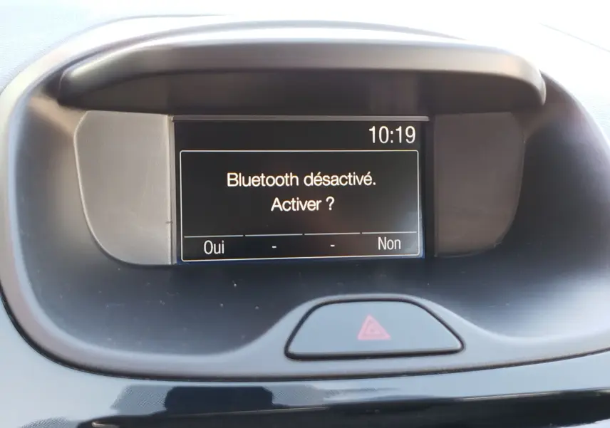 Écran central du tableau de bord de la Ford KA+ 2020 affichant un message Bluetooth désactivé, bouton de signal d'alerte visible.