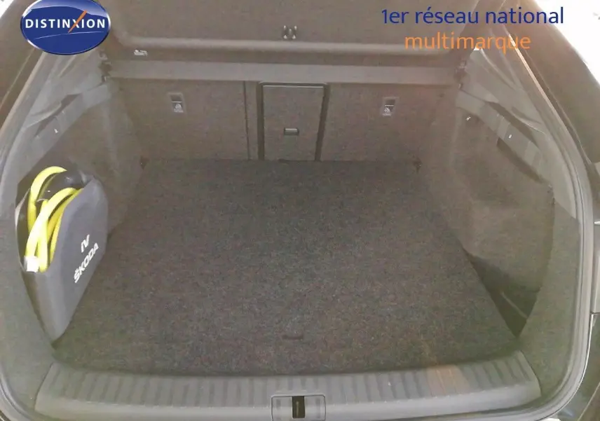 Coffre ouvert vu de l'arrière d'une Skoda Enyaq Coupé noire métal avec sac de câble de recharge électrique.