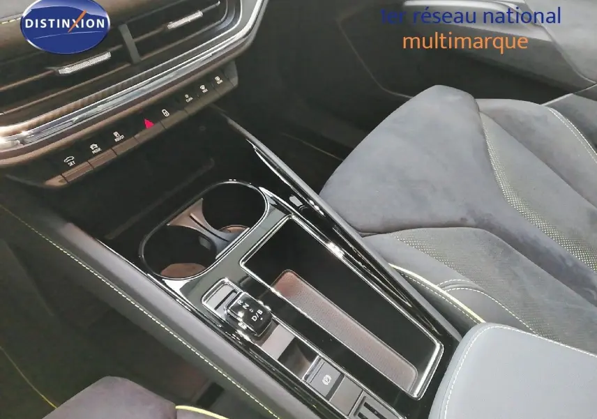 Vue rapprochée de la console centrale noire brillante et des sièges en tissu gris du Skoda Enyaq Coupé électrique 2022.