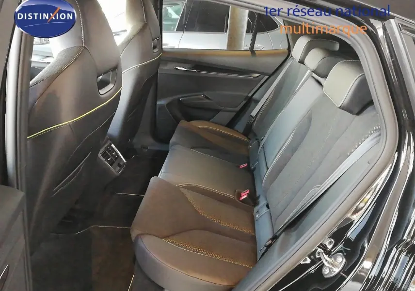 Vue latérale droite de l'intérieur arrière du Skoda Enyaq noir métal, montrant les sièges en cuir noir avec surpiqûres jaunes.