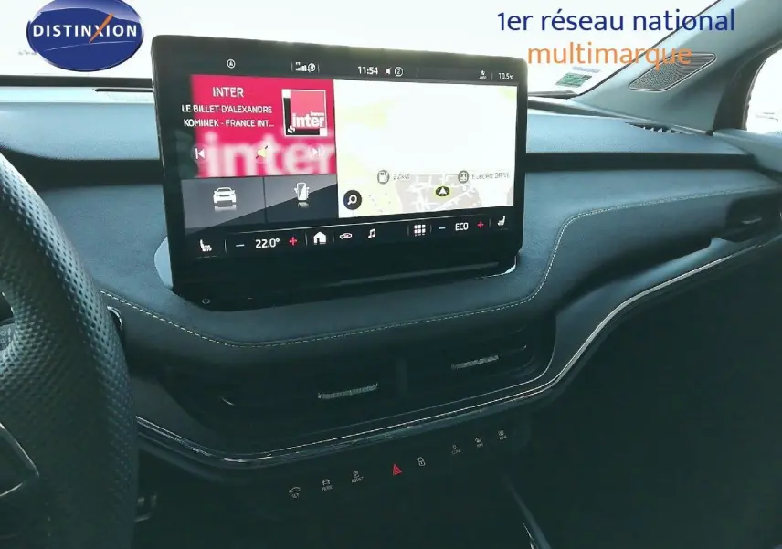 Tableau de bord noir avec écran tactile central affichant navigation et radio dans Skoda Enyaq Coupé électrique 2022.