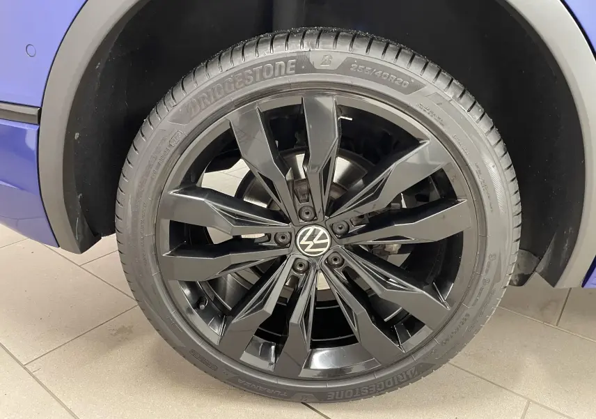 Gros plan sur la jante noire 20'' Suzuka du côté gauche d'un Volkswagen Tiguan Bleu Lapiz.